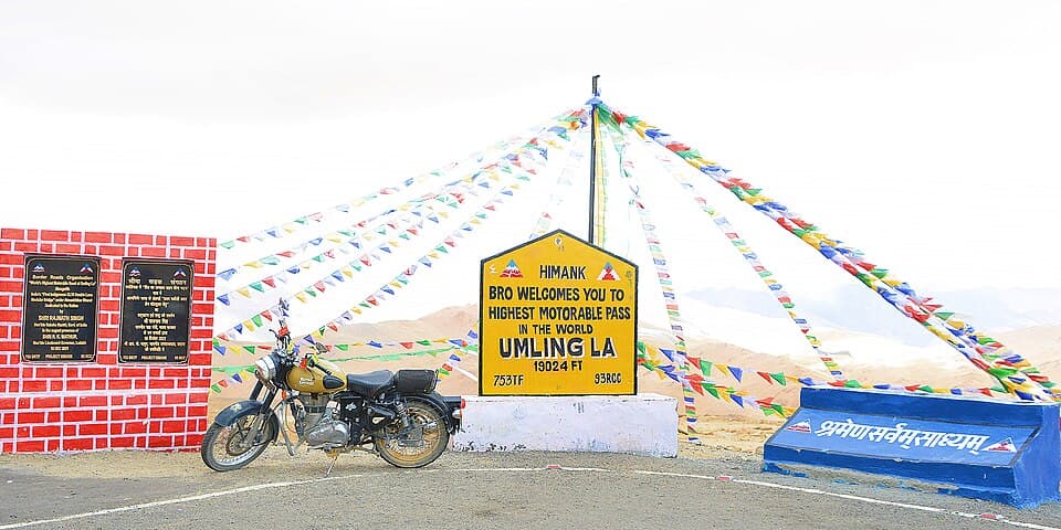 The signboard at Umling La, with a rider's motorcycle, on the Umling La route